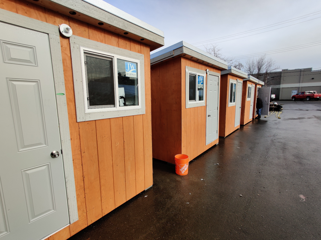 Eigtht-by-eight-foot sheds with a window, door and heater sit in a row at one of Duncan's tent sites for unhoused residents.