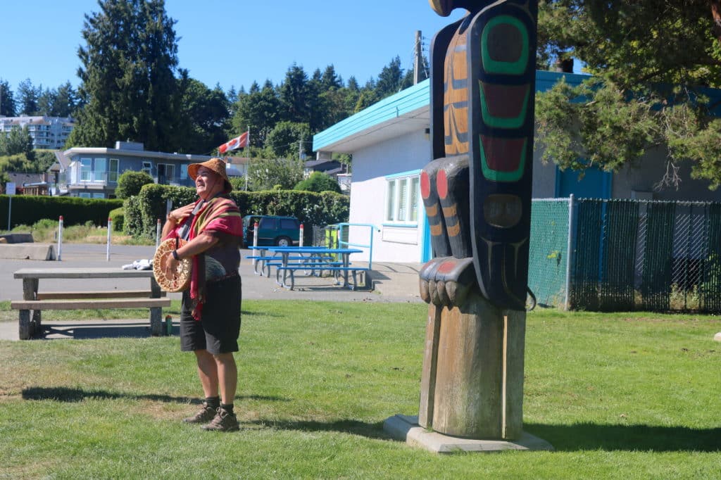Dave Spirit Wolf Bodaly stands in front of the Stiil'nep Welcome Portal as he tells The Discourse readers the meaning of each figure.