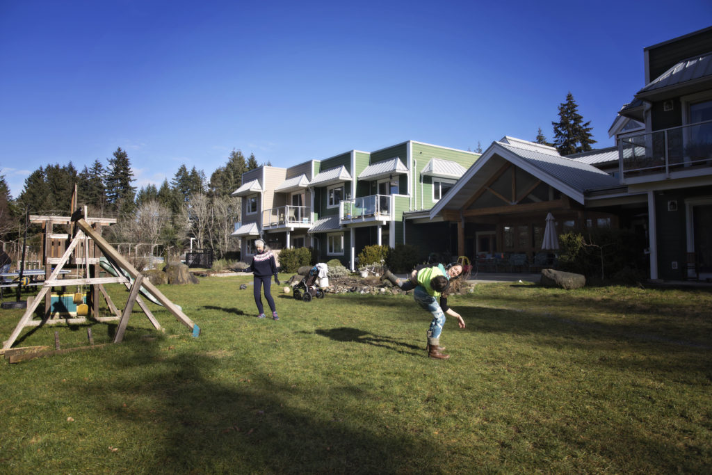 Residents of the Pacific Gardens cohousing Community enjoy the sunshine playing in their backyard.