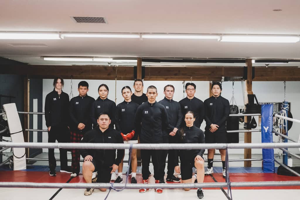 Members of Team 700 Indigenous youth boxing club stand for a group picture in the boxing ring.