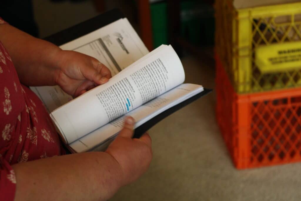 a person holds a book listing complex materials 