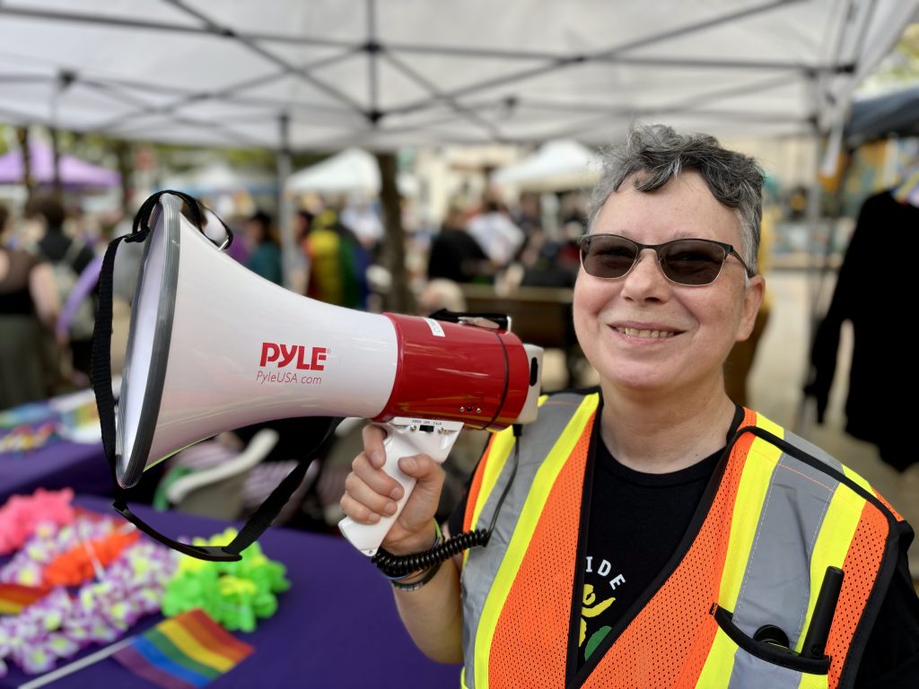 Cowichan Pride Society president Teresa Stebbing smiles and holds a megaphone